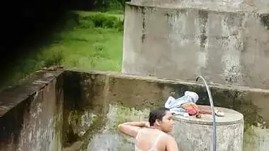 Indian village girl bathing near water tank outdoor