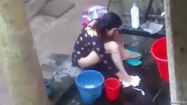 Naked Desi woman washes XXX assets outdoors not knowing about camera
